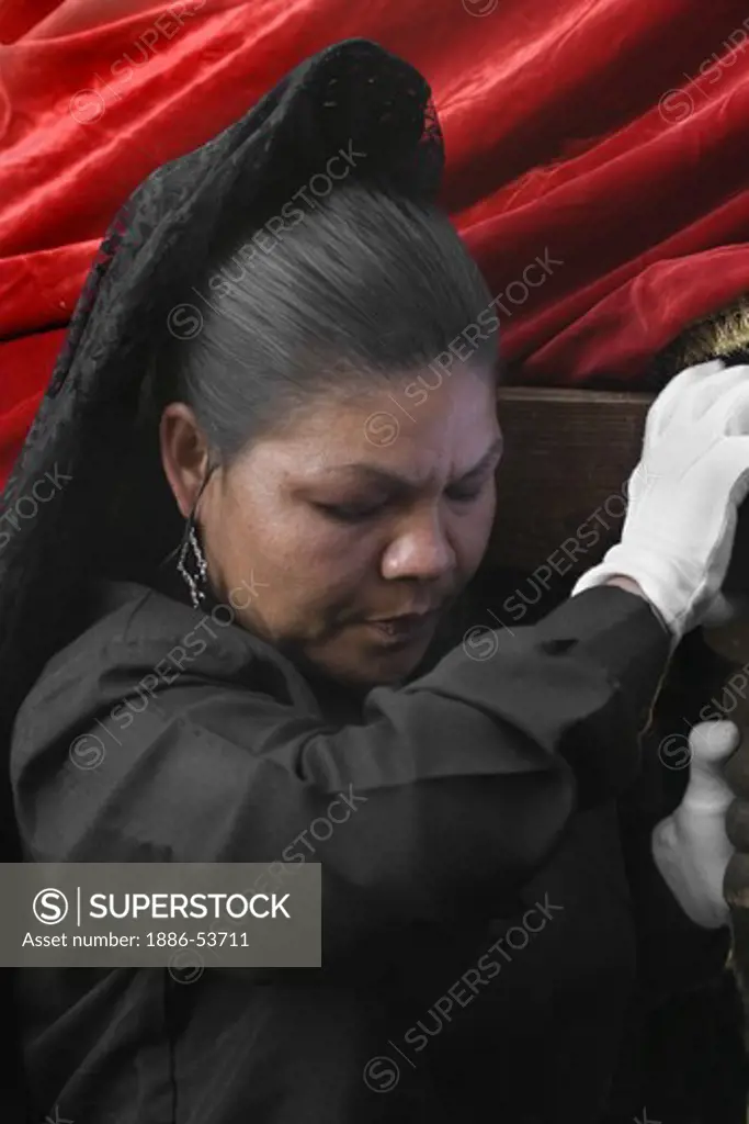 MEXICAN woman in black carries a statue during EASTER PROCESSION - TEMPLO DEL ORATORIO, SAN MIGUEL DE ALLENDE, MEXICO