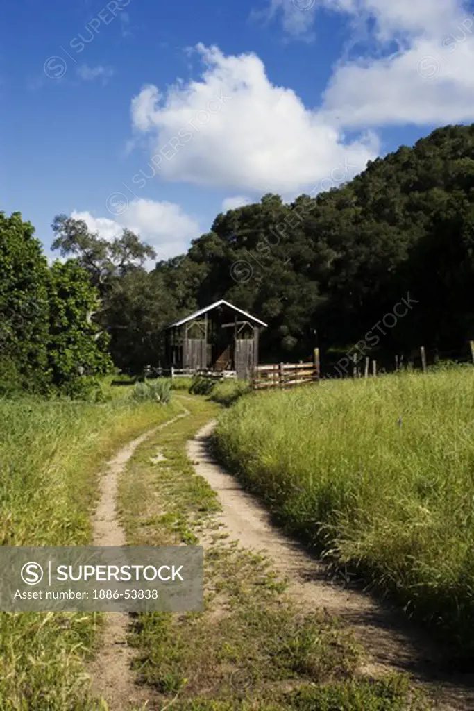 A dirt road winds its way to a barn on a cattle ranch in Monterey County, California