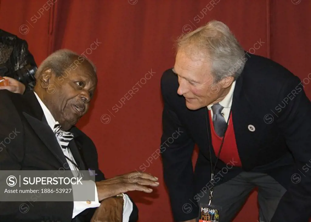 OSCAR PETERSON speaks while CLINT EASTWOOD listens intently backstage at THE MONTEREY JAZZ FESTIVAL
