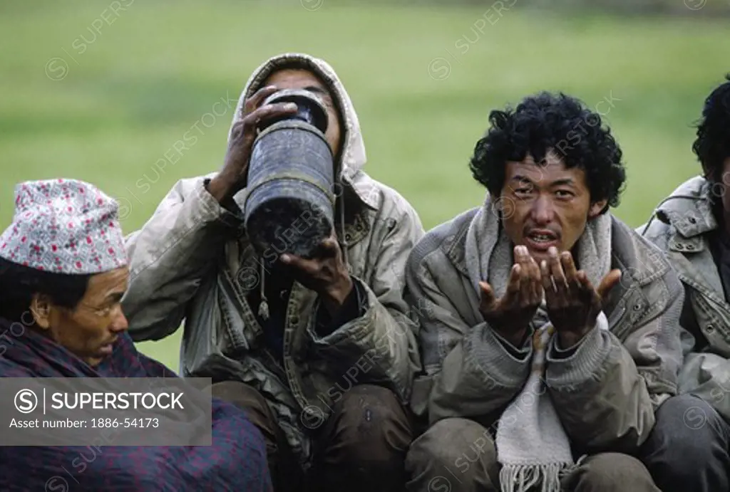 DOLPO MEN drink CHANG (liquor) during a Tibetan Buddhist FESTIVAL in the DO TARAP VALLEY - DOLPO, NEPAL