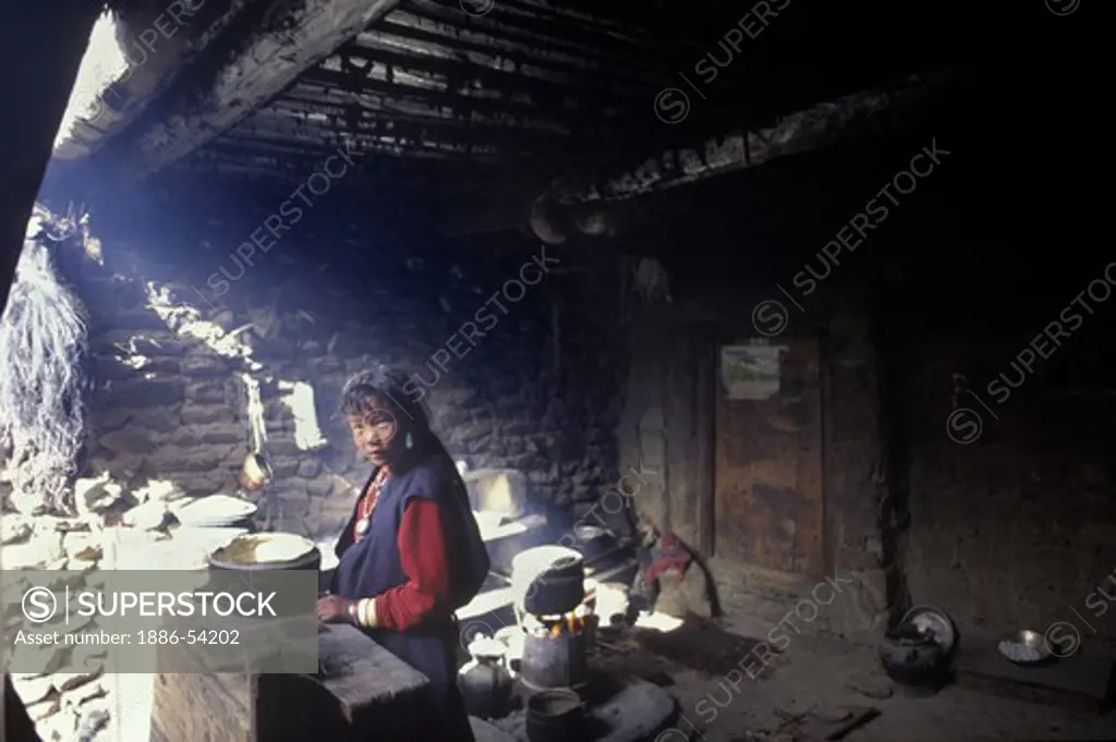 A DOLPO WOMAN cooks in the KITCHEN of SHIP CHOK MONASTERY in the DO TARAP VALLEY - DOLPO, NEPAL