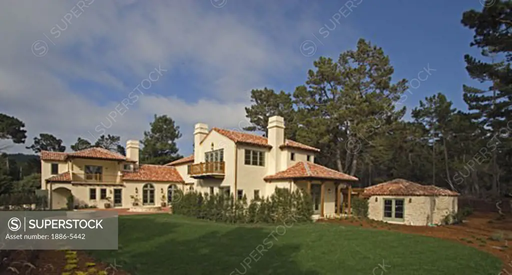 Exterior of a Spanish style luxury home with stucco walls and red tile roof 