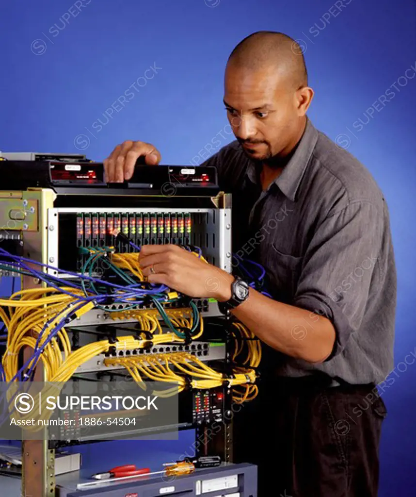 A technician works on a communications switch - MODEL RELEASED