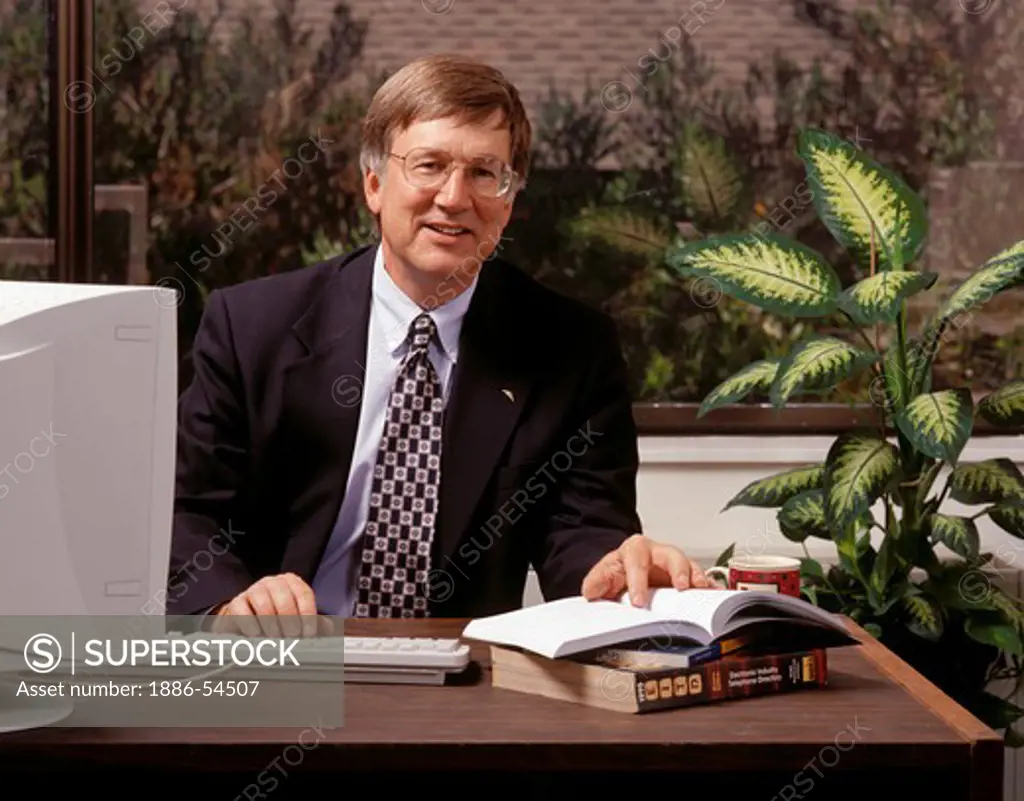 EXECUTIVE working with a computer in his office - MODEL RELEASED