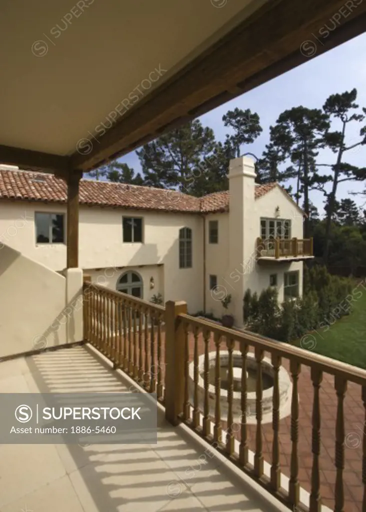 Exterior of a SPANISH STYLE CALIFORNIA LUXURY HOME with large red tiled PATIO as seen from upstairs deck