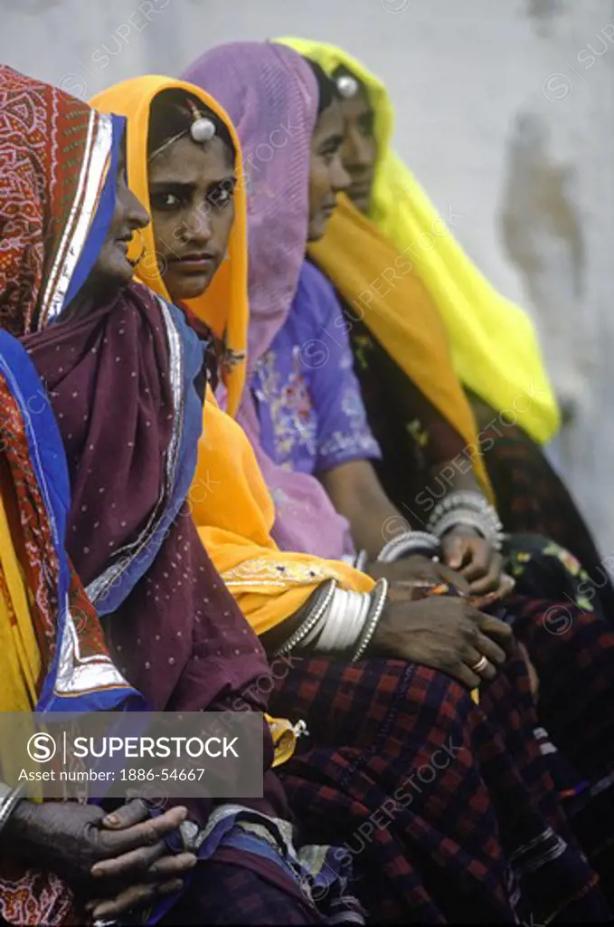 INDIAN WOMEN in MULTI-COLORED SARIS at the PUSHKAR CAMEL FAIR, a 5 day religious festival - RAJASTHAN, INDIA