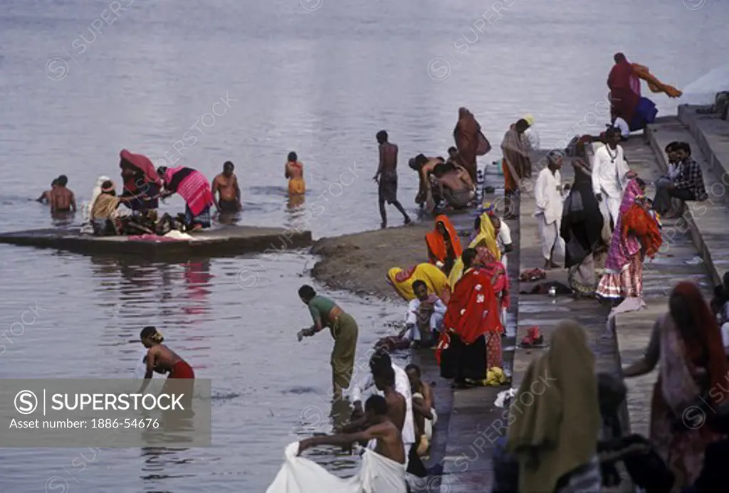 PILGRIMS bathing away their sins at HINDU TEMPLE GHATS on the LAKE at the PUSHKAR CAMEL FAIR - RAJASTHAN, INDIA