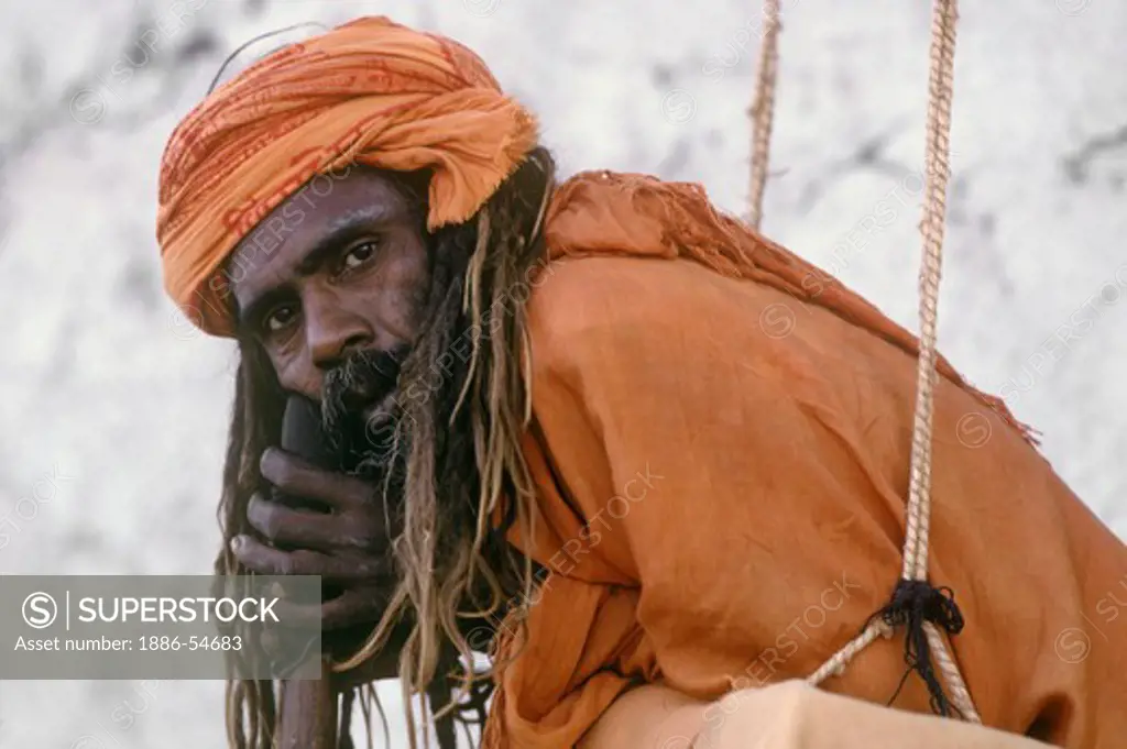 HINDU SADDHU in SWING with renunciate's vow to never lay on the ground at the PUSHKAR CAMEL FAIR - RAJASTHAN, INDIA