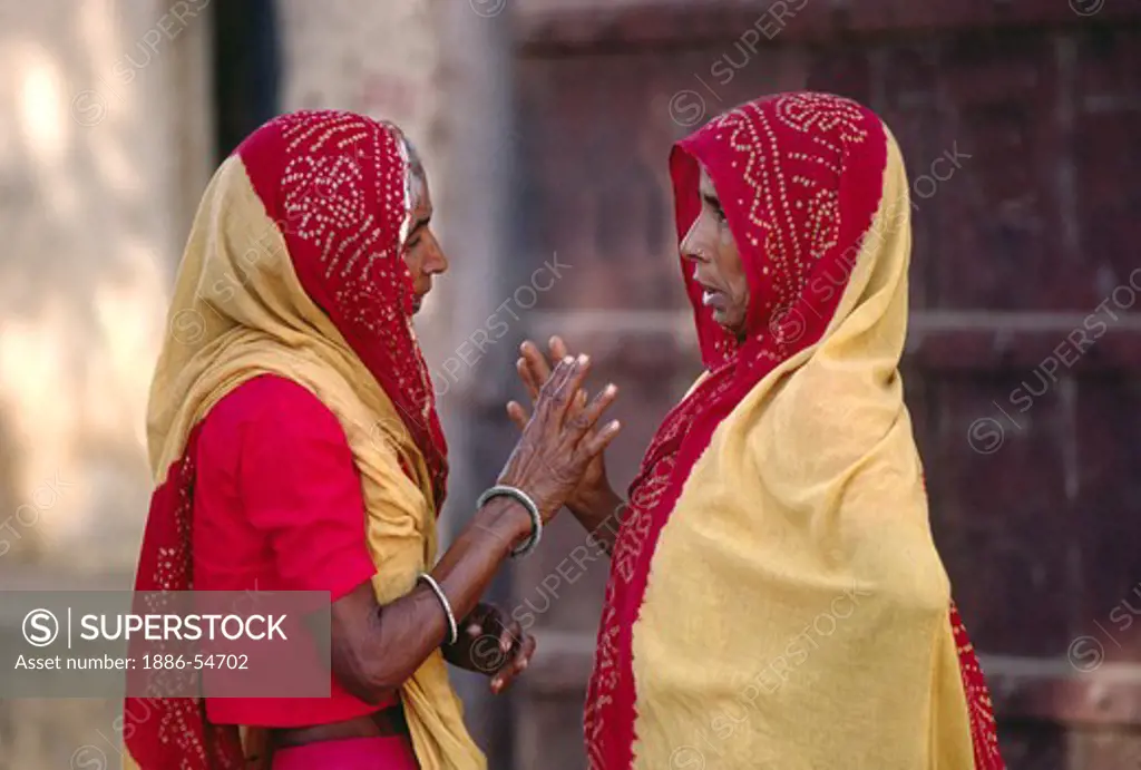Two RAJASTHANI WOMEN in traditional SARIS have a conversation in JAIPUR - RAJASTHAN, INDIA