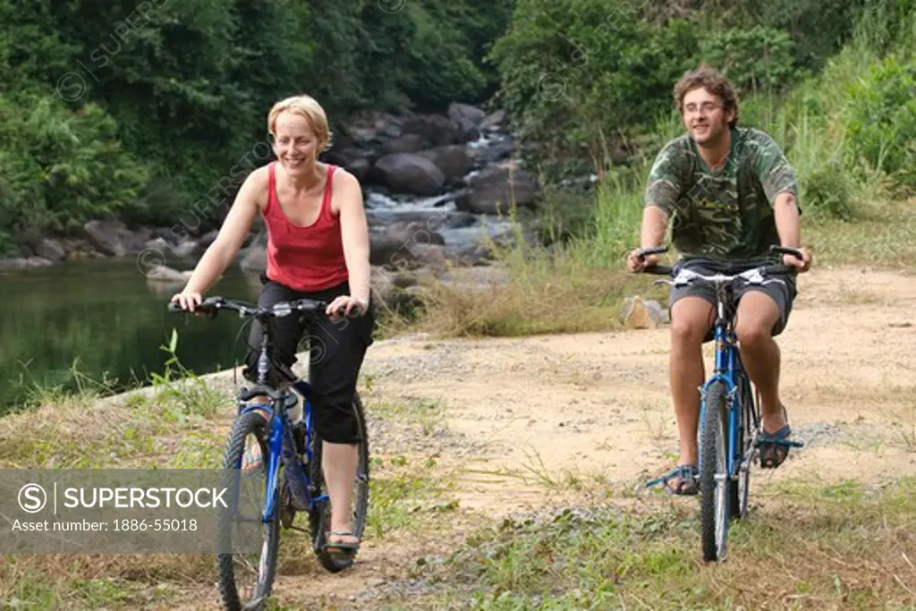 Adventure travelers go for a mountain bike ride near the Thai village of Kuraburi located near the North Andaman Sea - THAILAND