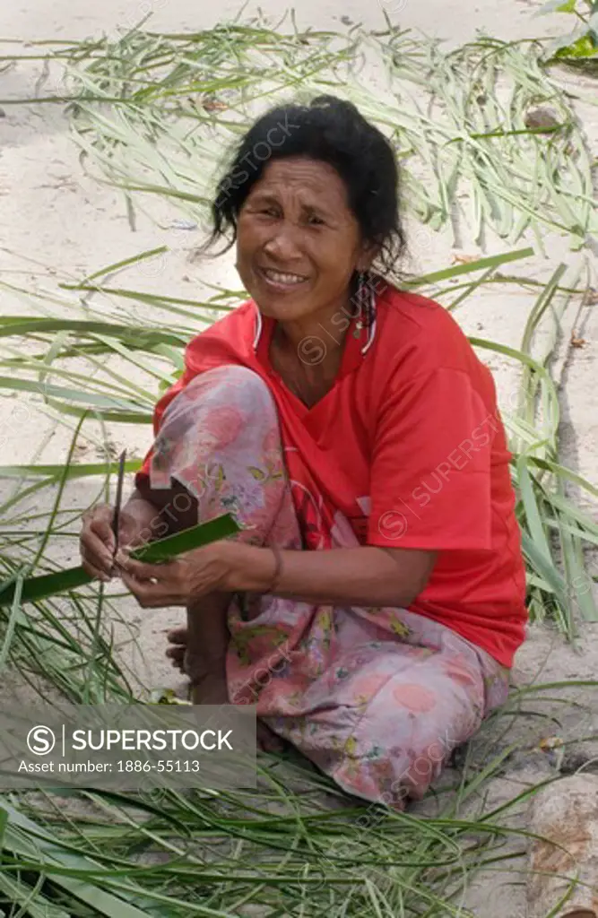 Moken (sea gypsy) women prepares plant for weaving baskets in her village on Ko Surin Thai Island in Mu Ko Surin National Park -  THAILAND