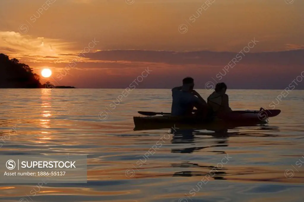 Kayakers enjoy a tropical sunrise on the North Andaman Sea off the coast of Ko Surin Nuea Island in Mu Ko Surin National Park, THAILAND