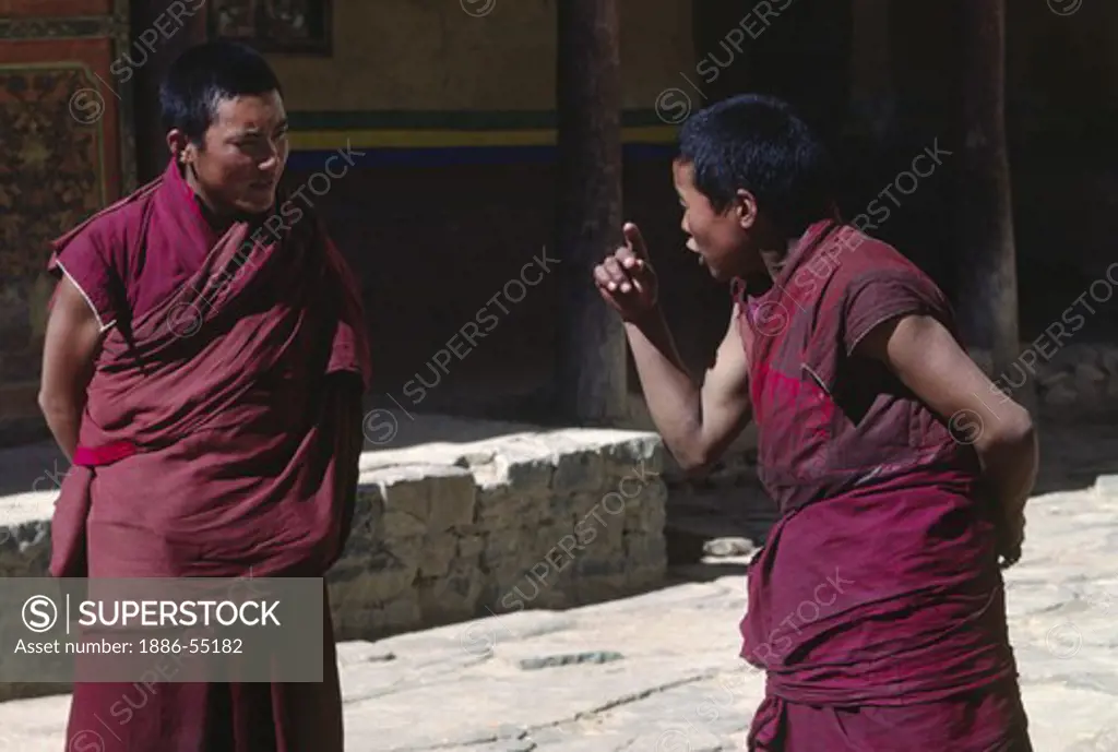 Monks practicing ritualized TIBETAN BUDDHIST debate at TASHILUHUNPO MONASTERY - SHIGATSE, TIBET