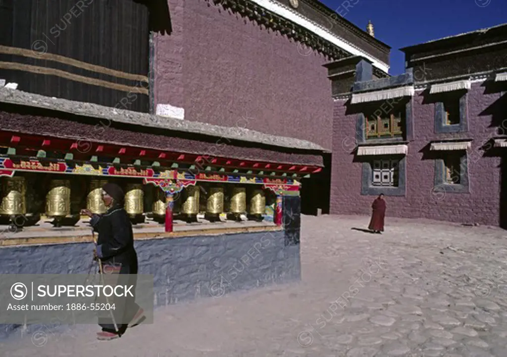 Pilgrim spins prayer wheels at Sakya Monastery - Sakya, Tibet