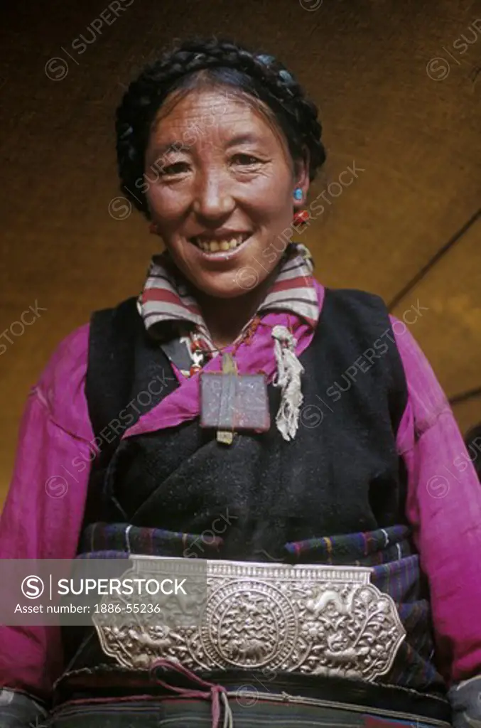 A FEMALE TIBETAN DROKPA (Tibetan nomadic yak herder) with large SILVER CHUBA CLASP - SOUTH WESTERN, TIBET