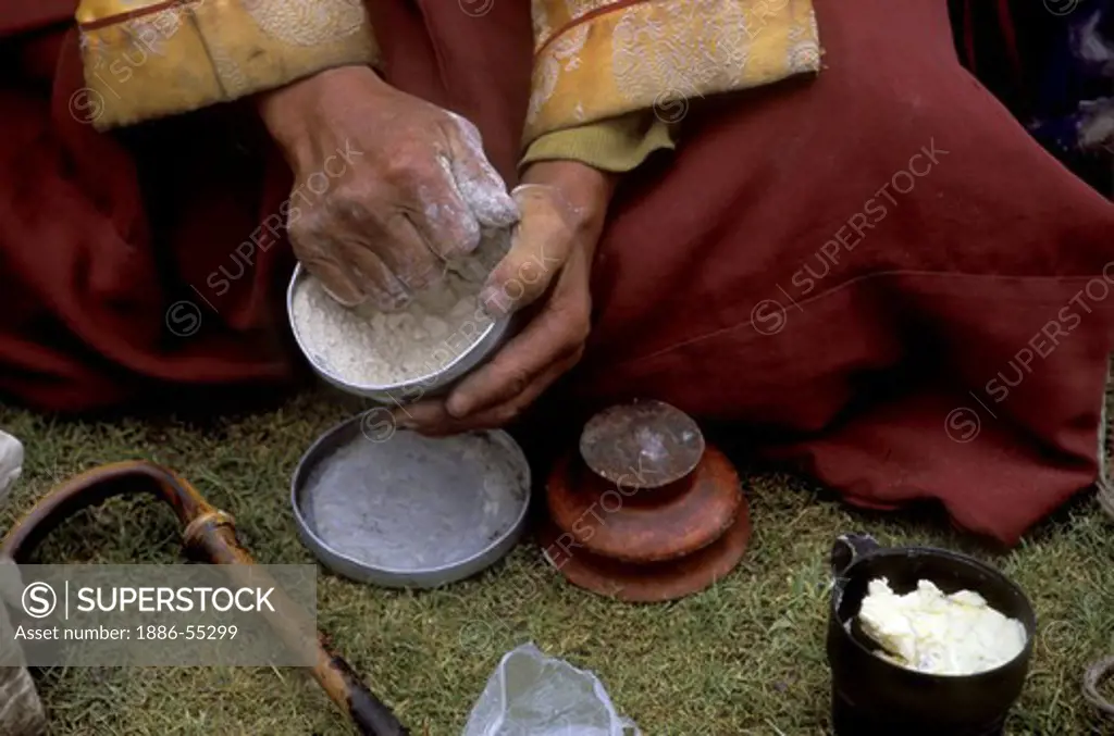 A BUDDHIST MONK eats TSAMPA while circling MOUNT KAILASH (6638 M) the most sacred HIMALAYAN PEAK - TIBET