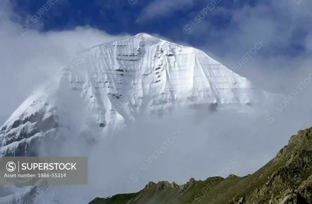 The mist enshrouded North Face of MOUNT KAILASH (6638 M) is a sacred site for BUDDHIST & HINDU  PILGRIMS - TIBET