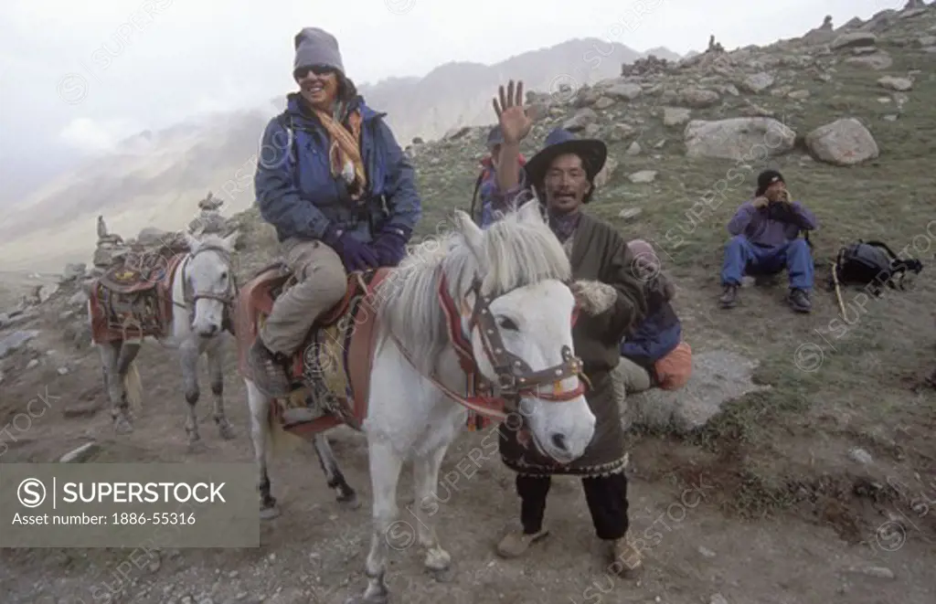 woman  rides a HORSE around MOUNT KAILASH (6638 M), the most sacred HIMALAYAN PEAK in TIBET