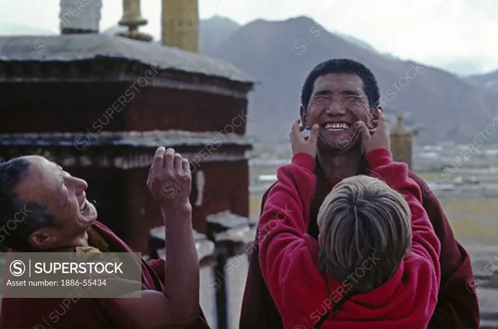 American man entertains the Ma Shee Lama of Sera Monastery & his helper - LHASA, TIBET