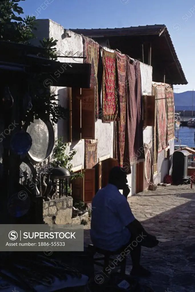 Shop owner takes a cigarette break in the coastal village of  KAS - TURQUOISE COAST, TURKEY