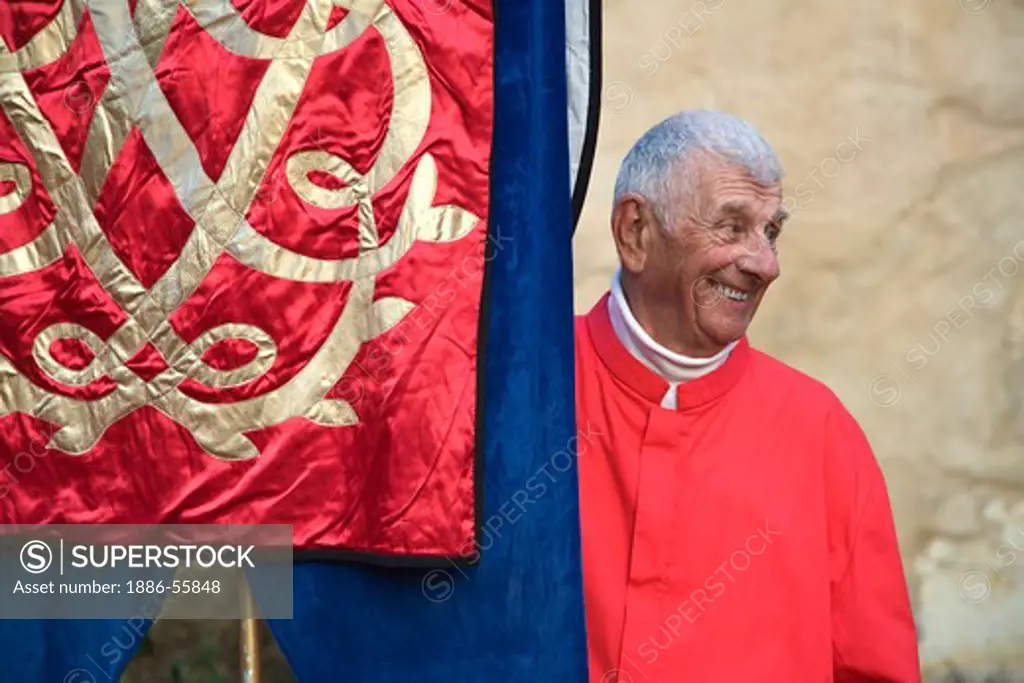 A Church member carries a banner during a reenactment the MEDIEVAL TRADITION during the CARMEL BACH FESTIVAL - CARMEL MISSION, CALIFORNIA