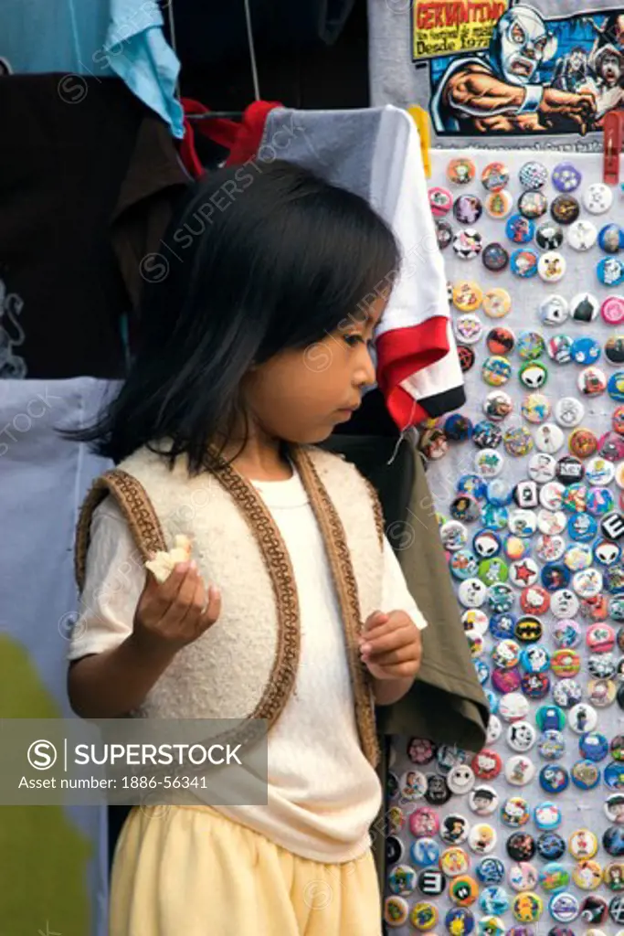 A young MEXICAN GIRL stands next to a BUTTON DISPLAY - GUANAJUATO, MEXICO