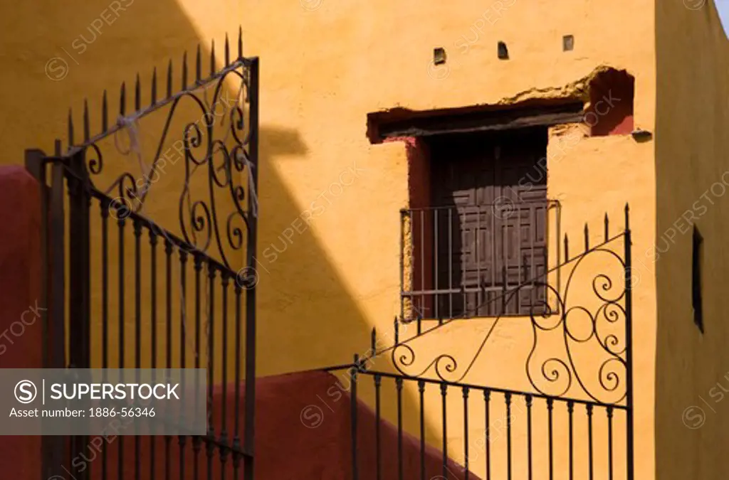 Yellow and red and the traditional colors of COLONIAL MEXICO as seen here with a WROUGHT IRON GATE - GUANAJUATO, MEXICO
