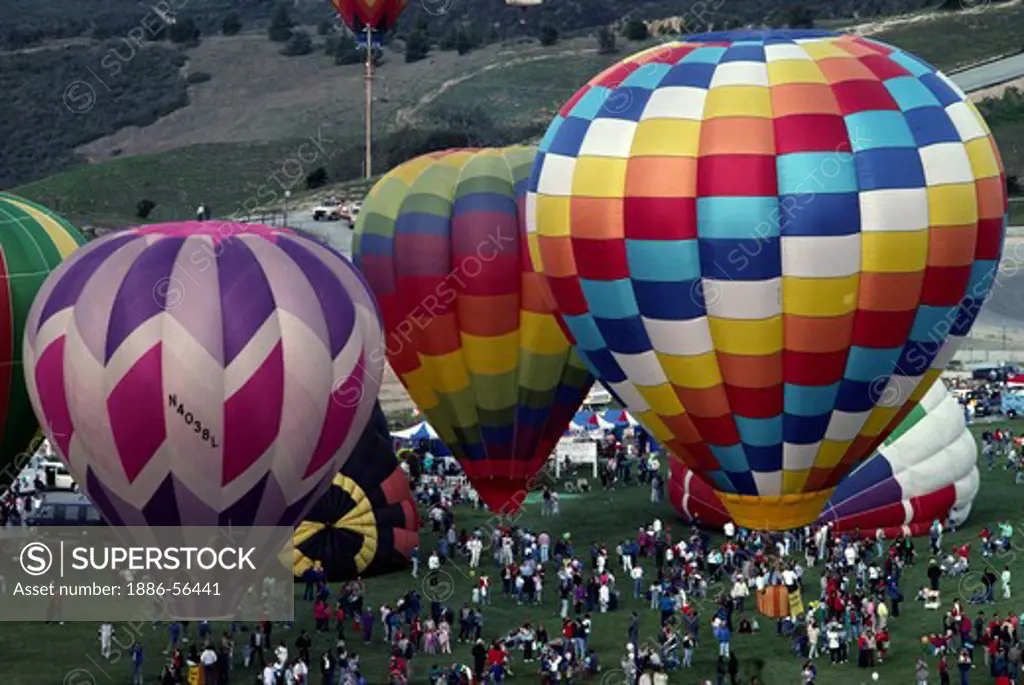 Colorful and creative HOT AIR BALLOONS lifting off from the ground - MONTEREY HOT AIR AFFAIR, CALIFORNIA