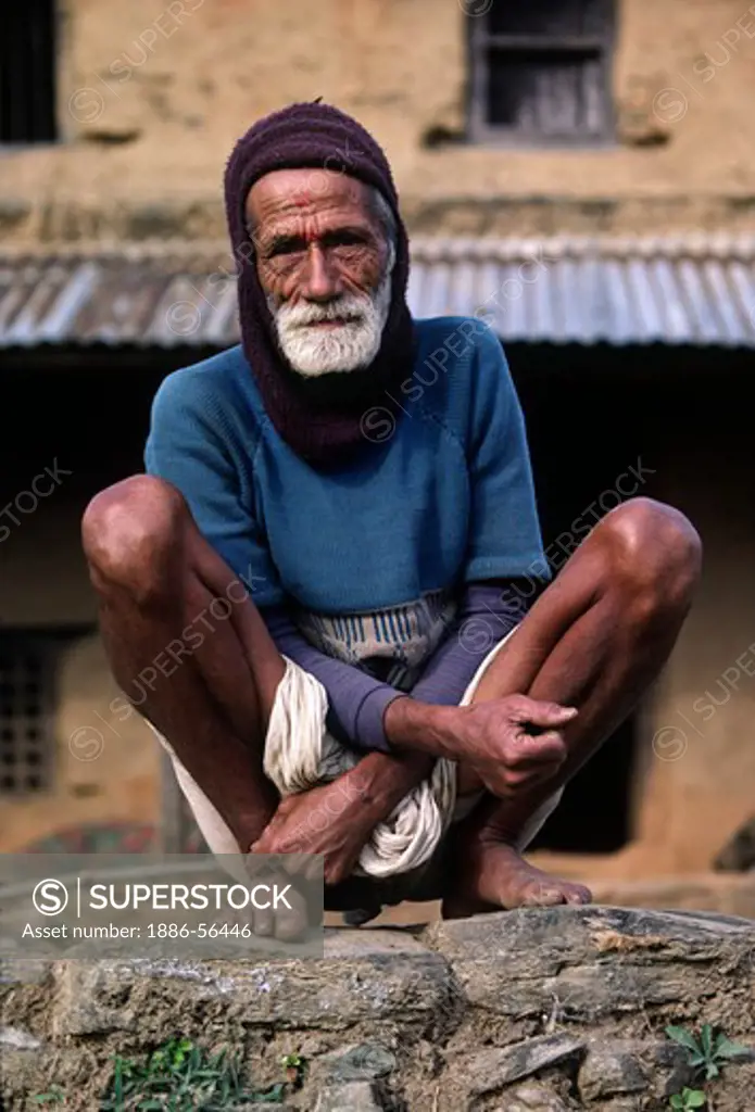 Siklis village elder squats NEPALI style - SIKLIS, NEPAL