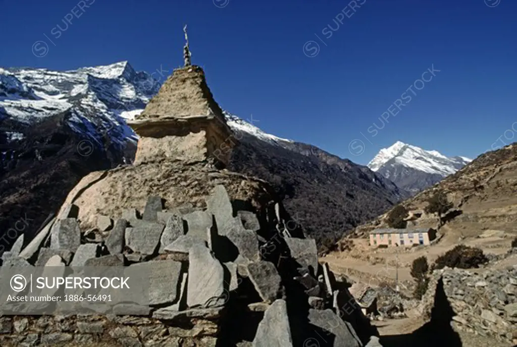 A TIBETAN BUDDHIST CHORTEN with MANI STONES on route to MOUNT EVEREST which is visiblebehind Lhotse - KHUMBU DISTRICT, NEPAL