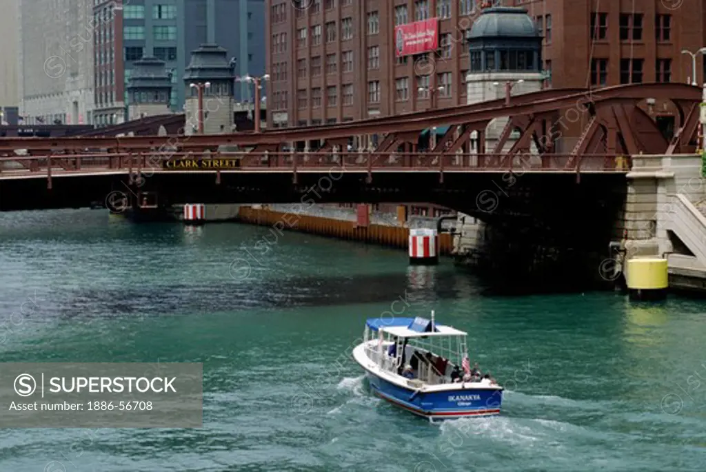 the IKANAKYA motor boat heads under the CLARK STREET BRIDGE which crosses the CHICAGO RIVER - CHICAGO, ILLINOIS