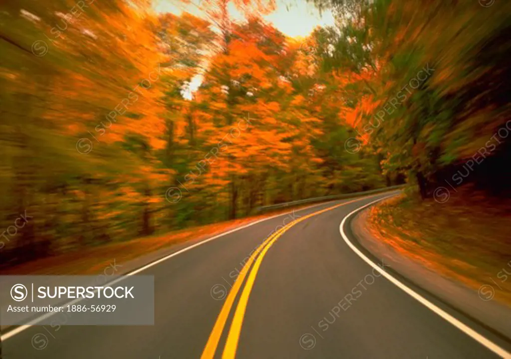 Turn in the road with blurred motion effect and fall foliage, Ohio.