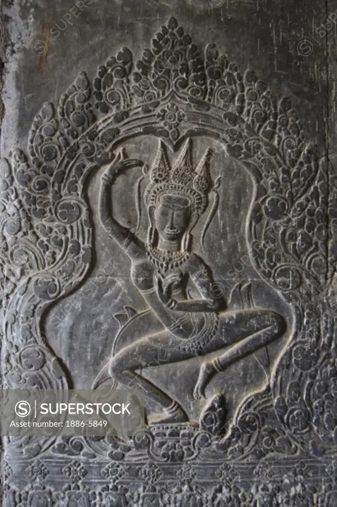 A stone carved bas relief Apsara (dancing celestial maiden) at Angkor Wat, built in the 11th century by Suryavarman the 2nd,  -  Cambodia 