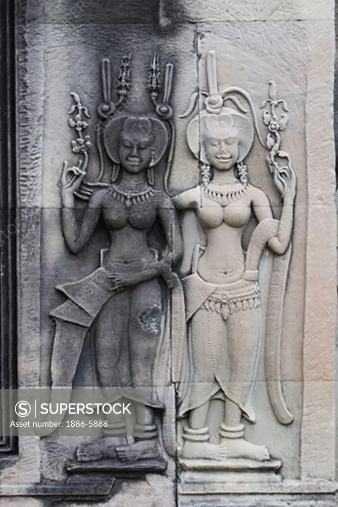 Stone carved bas relief of two smiling Apsaras (celestial maidens) at Angkor Wat, built in the 11th century by Suryavarman the 2nd,  -  Cambodia 