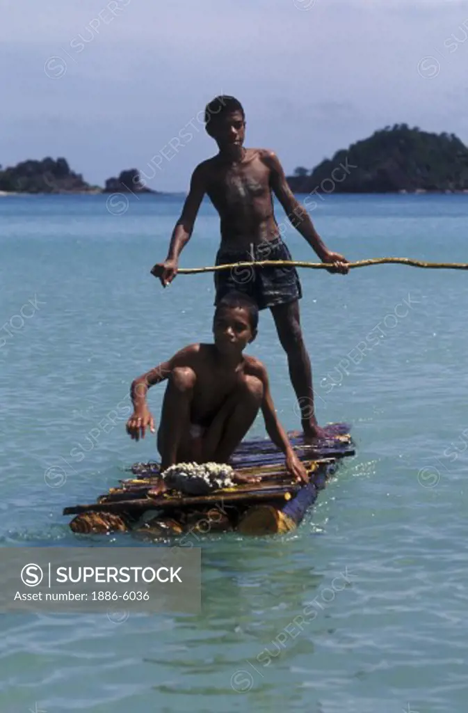 VILLAGE BOYS on homemade bark RAFT near  MALA KATI VILLAGE on NACULA ISLAND - YASAWA ISLANDS, FIJI