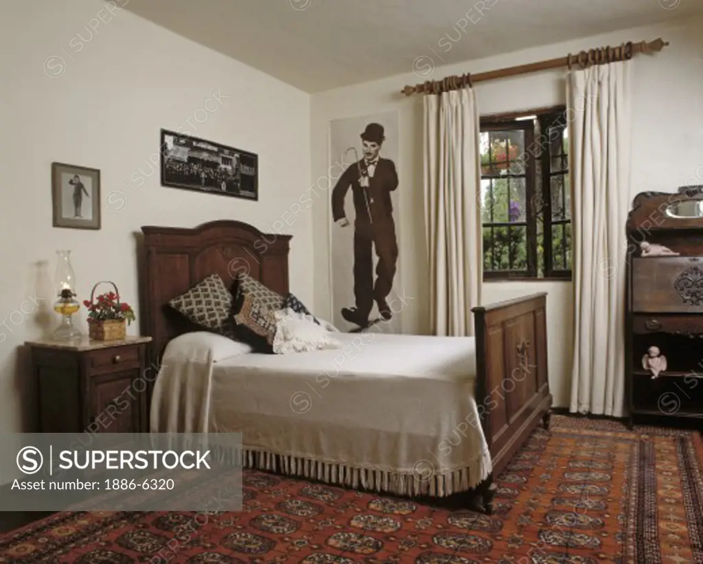 BEDROOM with antique wooden furniture including bed, side table and a poster of CHARLIE CHAPLIN 