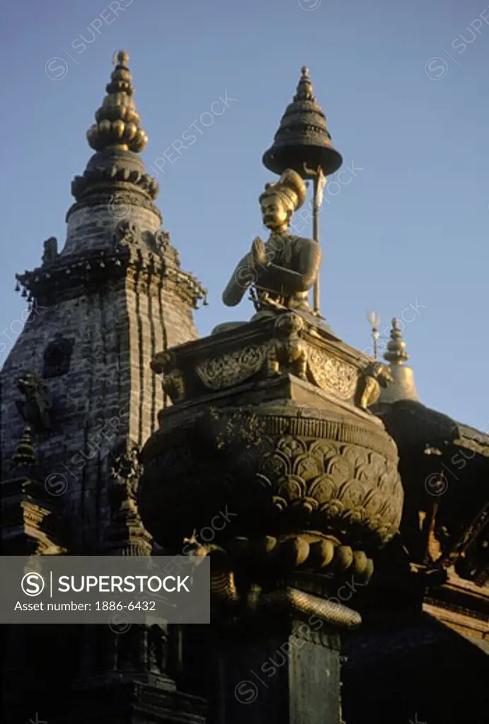 A bronze statue of king Bupathindra Malla sits on a stone pillar in Bhaktapurs's Durbar Square.