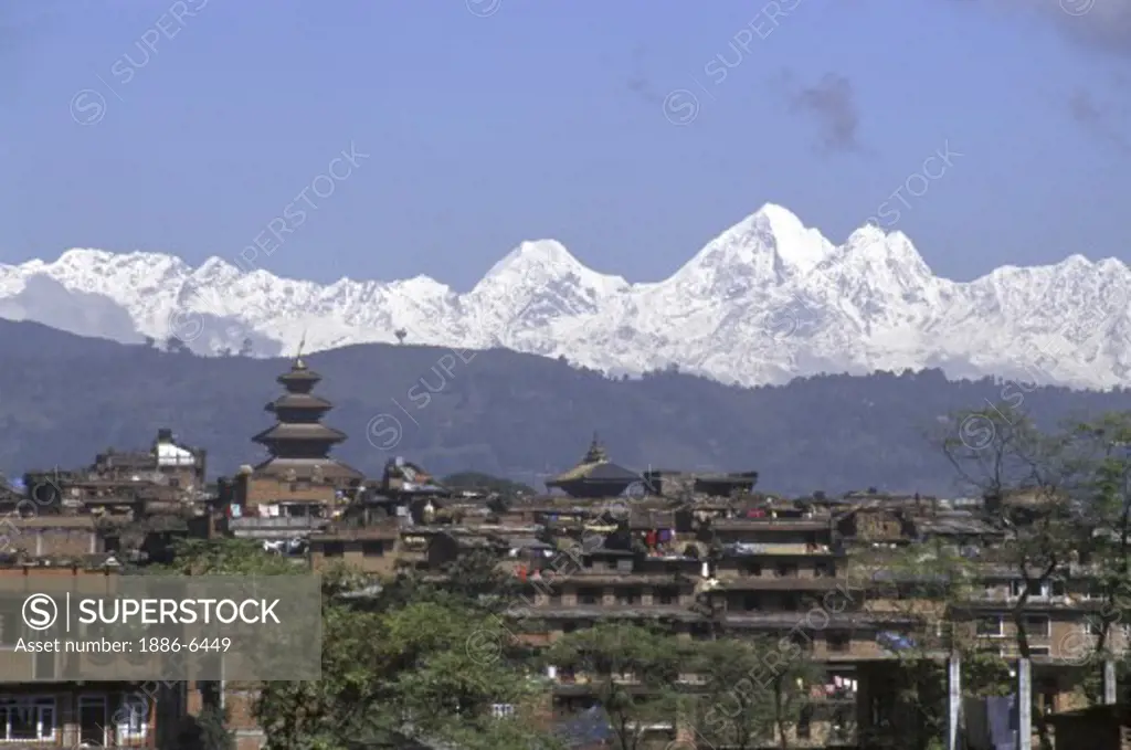 The mighty HIMALAYAN MOUNTAINS rise behind the city of BHAKTAPUR in the KATHAMANDU VALLEY - NEPAL
