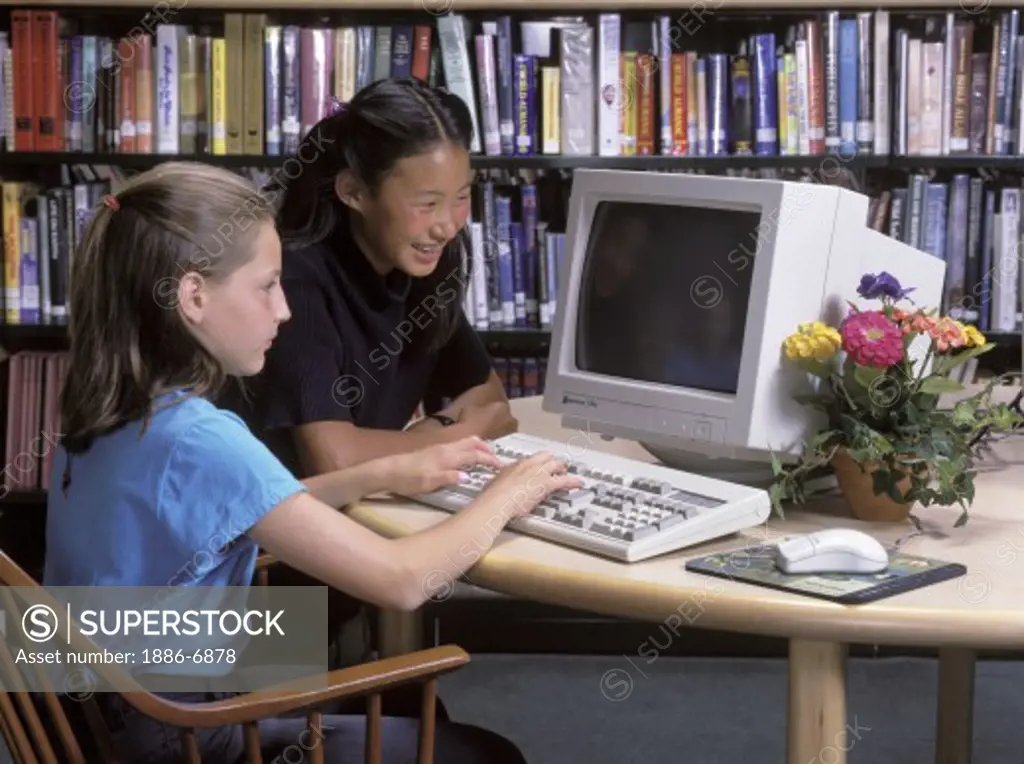 School children learn how to use computers as part of their regular curriculum in the library of a middle school - MODEL RELEASED 