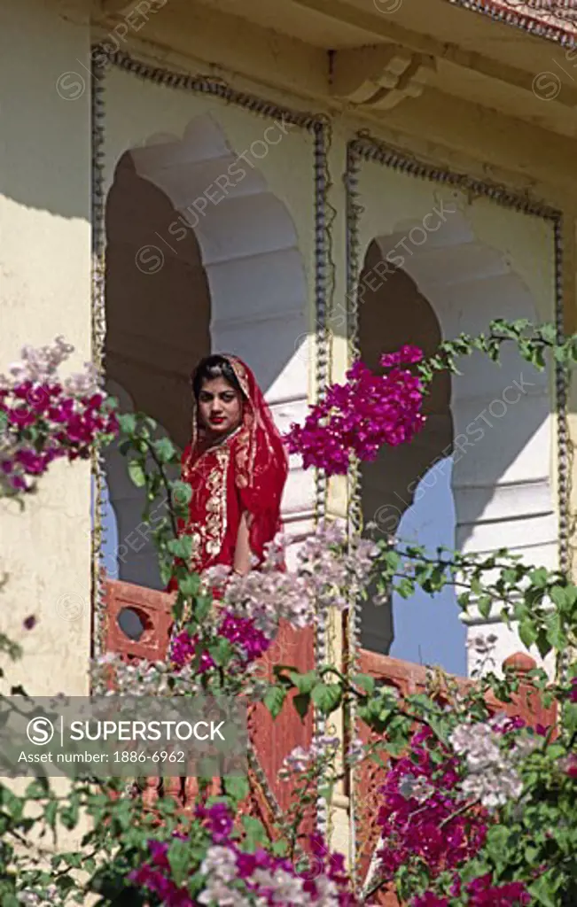 BRIDE of JAIPUR ROYALTY with traditional gold embroidered RED WEDDING SARI in a garden before marriage - RAJASTHAN, INDIA 