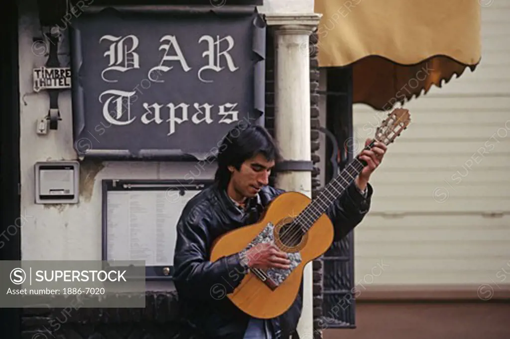A Spaniard plays FLAMENCO GUITAR outside a restaurant in SEVILLA - SPAIN