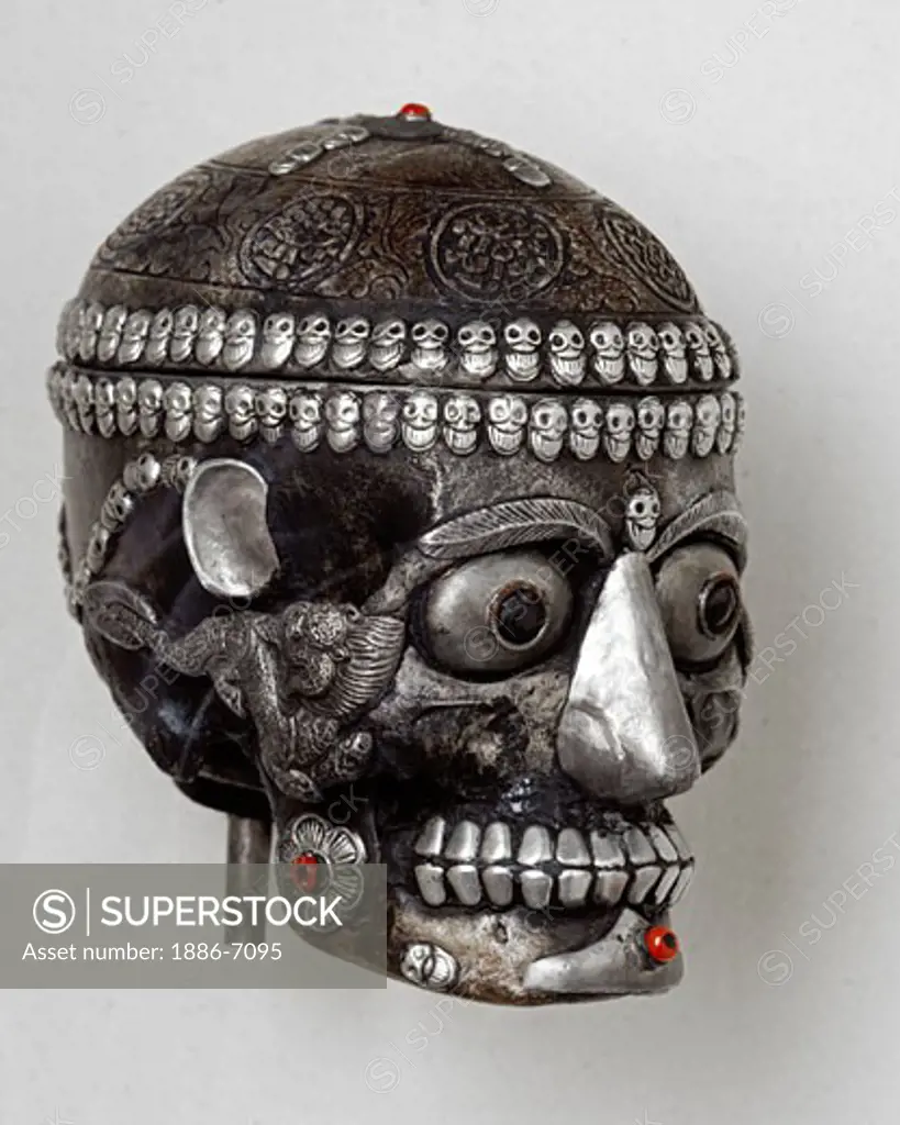A carved HUMAN SKULL covered with tooled SILVER is a Tibetan Buddhist ritual object
