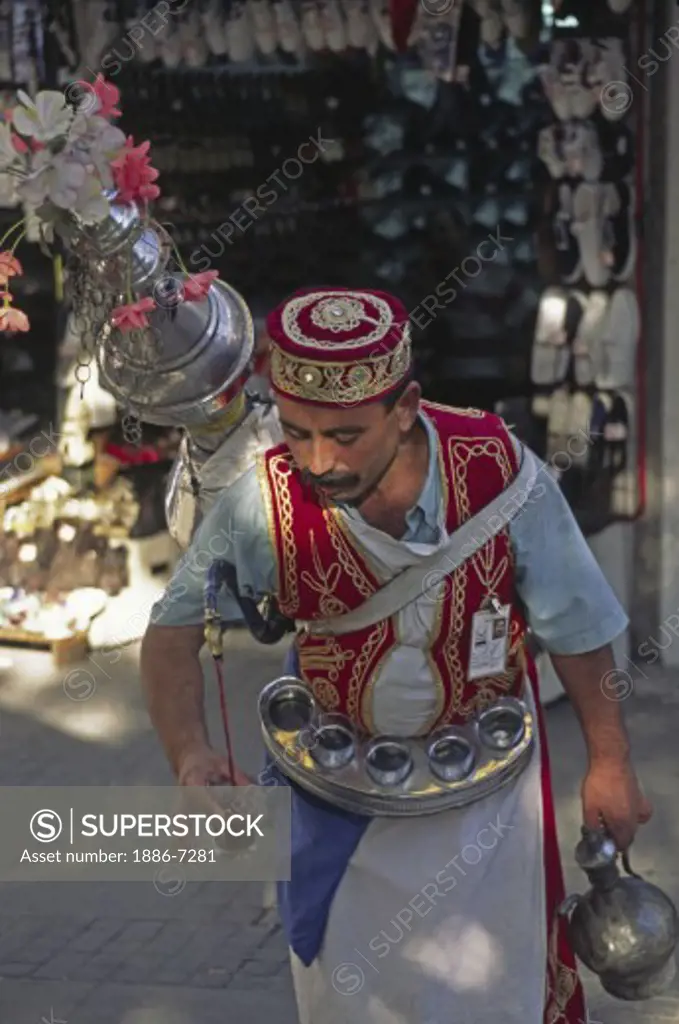 Traditional Turkish juice seller pours his refreshment from his giant pot - Covered Bazaar, Istanbul, Turkey