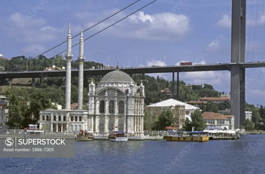 THE ORTAKOY MOSQUE sits underneath the BOGAZICI KORPUSU (bridge) on the BOSPHORUS - ISTANBUL, TURKEY