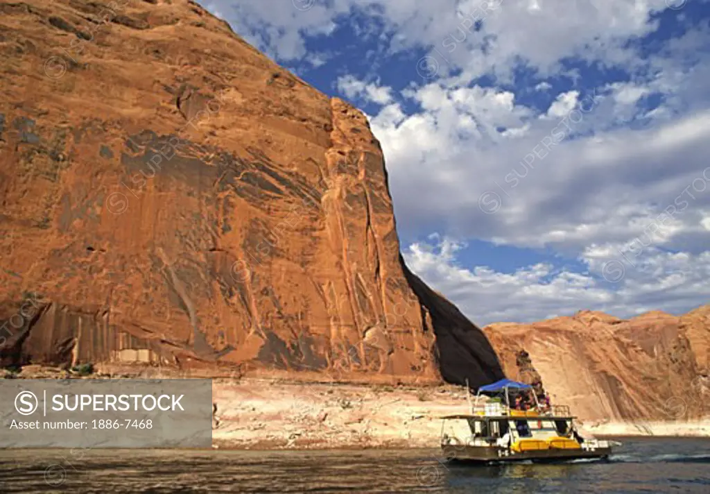 A HOUSE BOAT enters REFLECTION CANYON, one of 96 arms of LAKE POWELL NATIONAL RECREATION AREA - UTAH