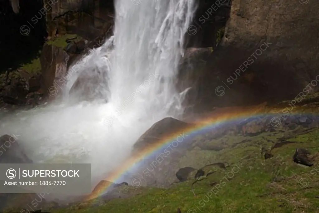 A rainbow forms from the mist of VERNAL FALLS which drops 317 feet during the SPRING run off - YOSEMITE NATIONAL PARK, CALIFORNIA