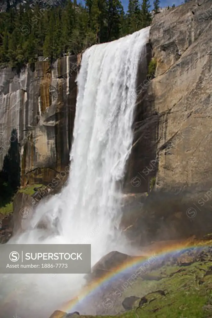 A rainbow forms from the mist of VERNAL FALLS which drops 317 during the SPRING run off - YOSEMITE NATIONAL PARK, CALIFORNIA