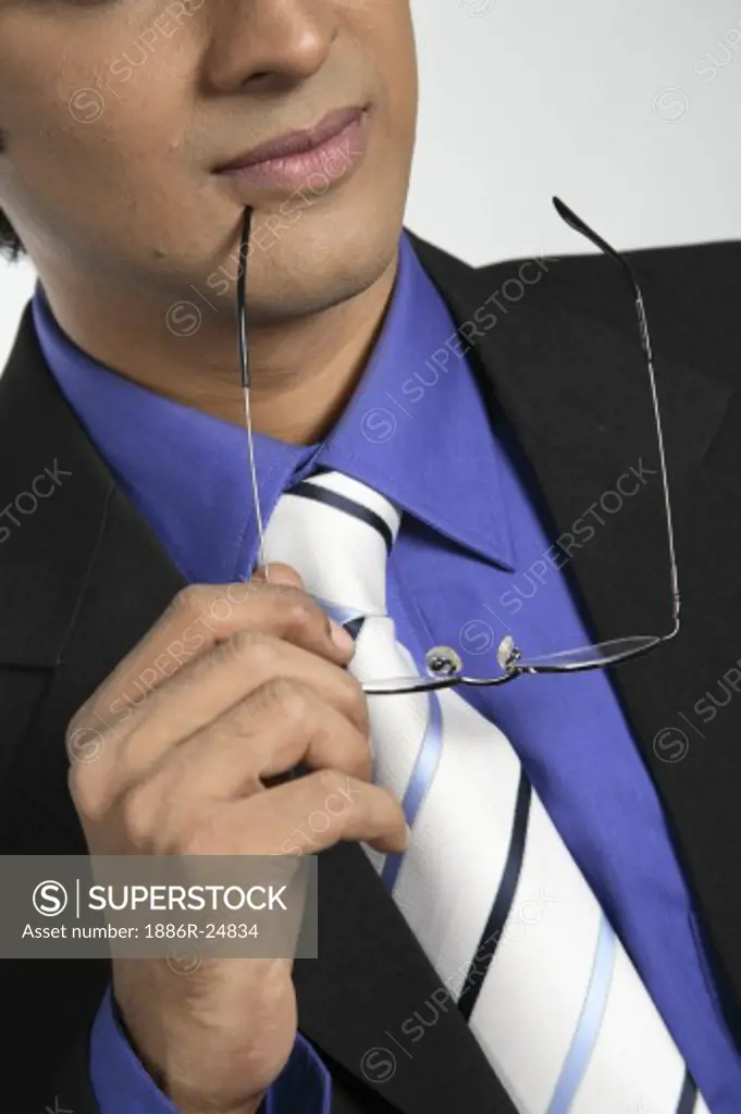 Executive holding spectacles