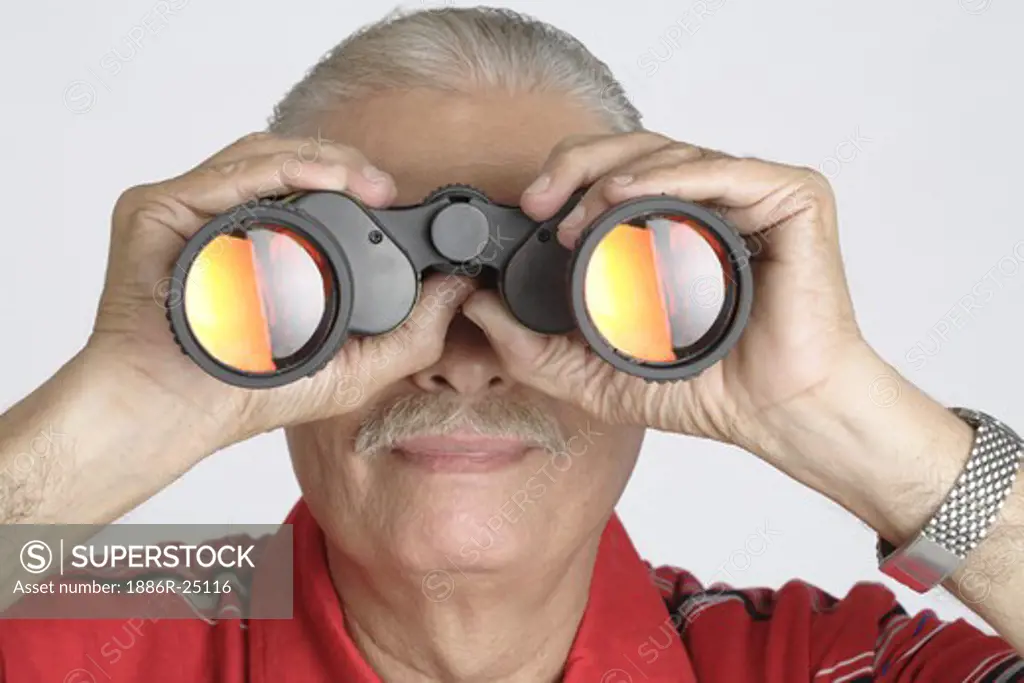 Old Man wrist watch Holding binoculars and looking through binoculars, Senior citizen, old man wearing red T Shirt with gray, black and white stripes, MR # 703B