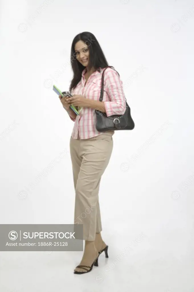 Young girl, smiling, open hair, holding mobile phone, two books in her hand, purse on the shoulder, MR # 703C